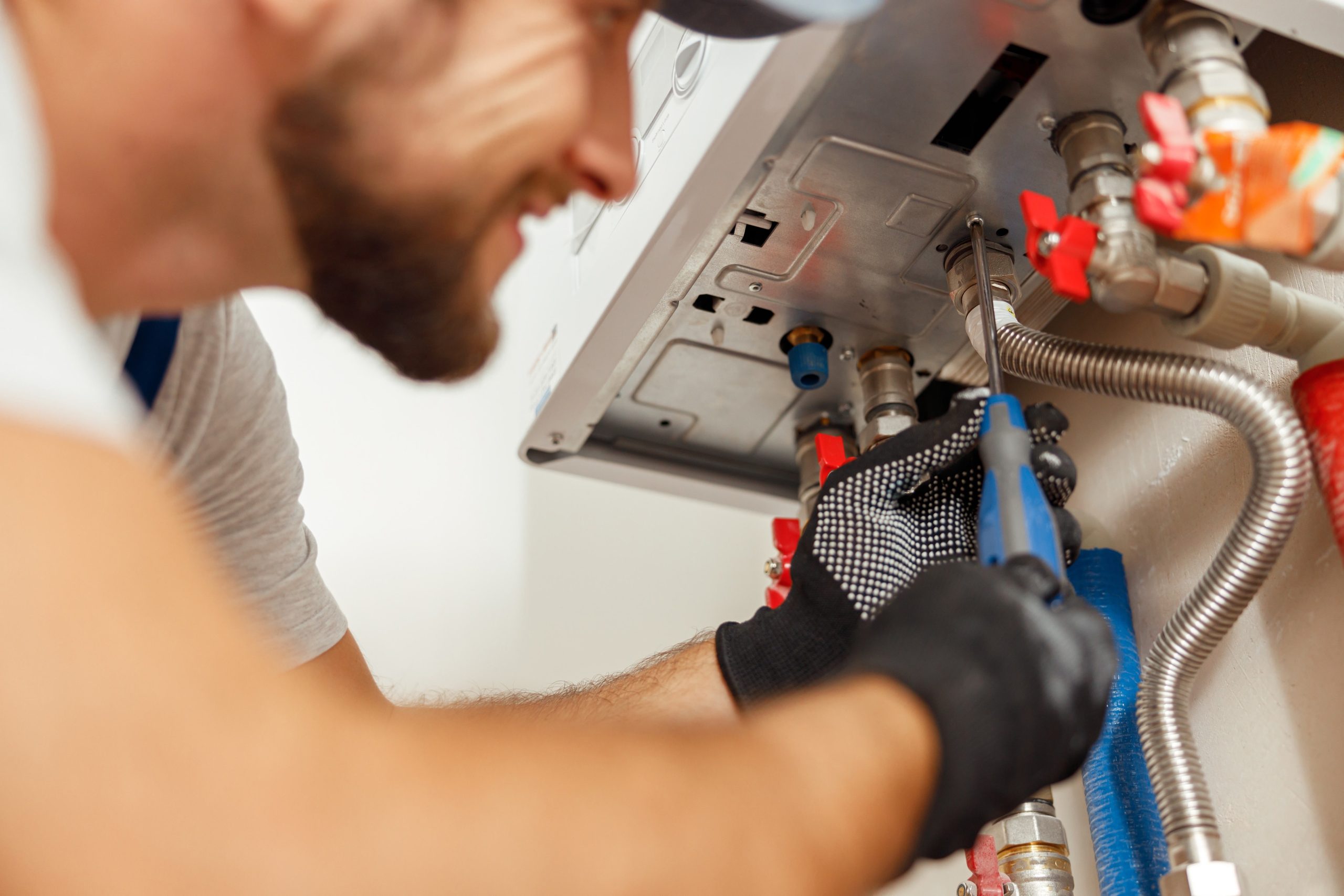 Man doing boiler repair to prepare for winter